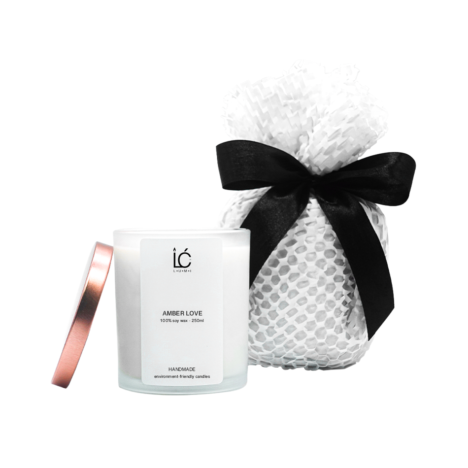 Amber Love Scented Soy Candle (250ml) with lid removed, beside eco-friendly gift wrap tied with a black ribbon