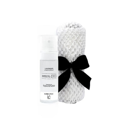 Lavender LUMI Room and Linen Spray (100ml) bottle wrapped in a white woven textured cloth tied with a black ribbon bow