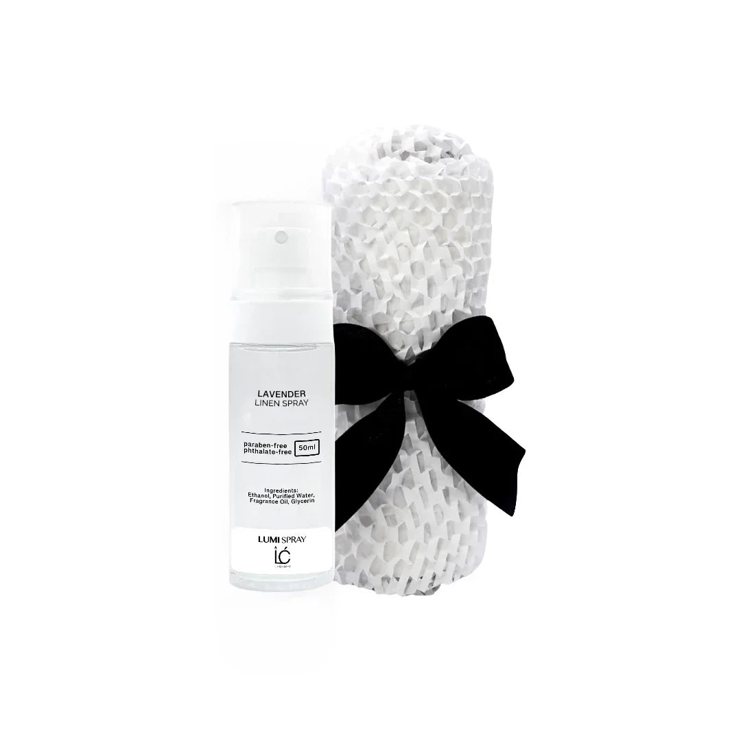 Lavender LUMI Room and Linen Spray (50ml) bottle wrapped in a white woven textured cloth tied with a black ribbon bow