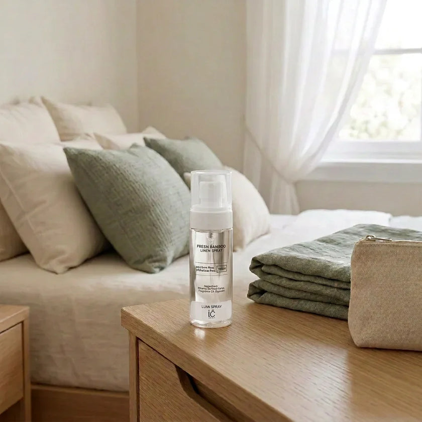 Fresh Bamboo LUMI Room and Linen Spray (100ml) bottle styled on a nightstand with folded sage-green linen and a small pouch